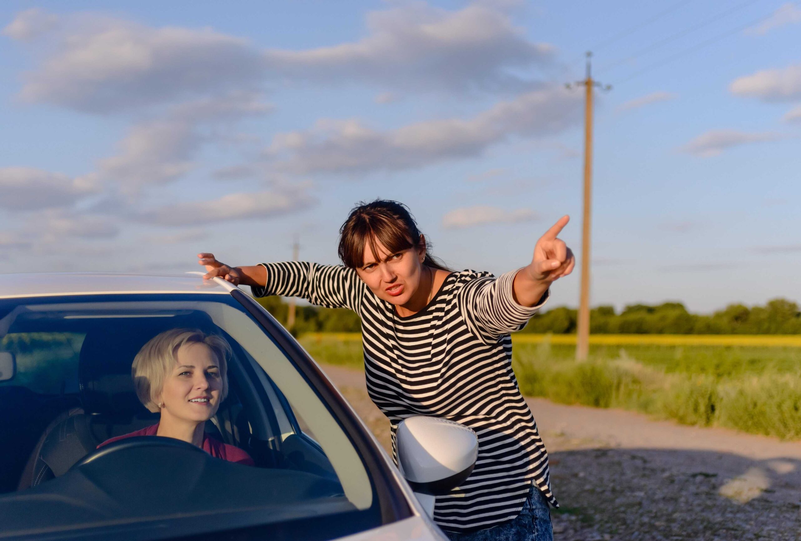 Woman giving directions to a lost driver who is driving a rental car in a foreign country.
